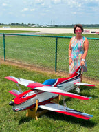 CK Aero Almira Bipe in the red, white and purple standard scheme on the grass at the field, with Almira Hebert, after whom the model is named
